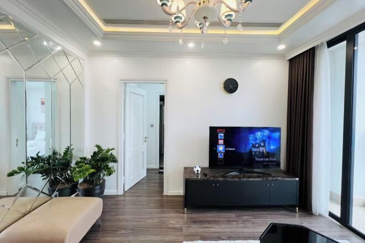 Una sala de estar moderna con una televisión de pantalla plana, un sofá y plantas en macetas.