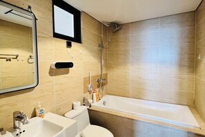 A bathroom with a bathtub, sink, toilet, and mirror. - Alex'housing Vinhome D'capitale luxury apartment (Hanoi)