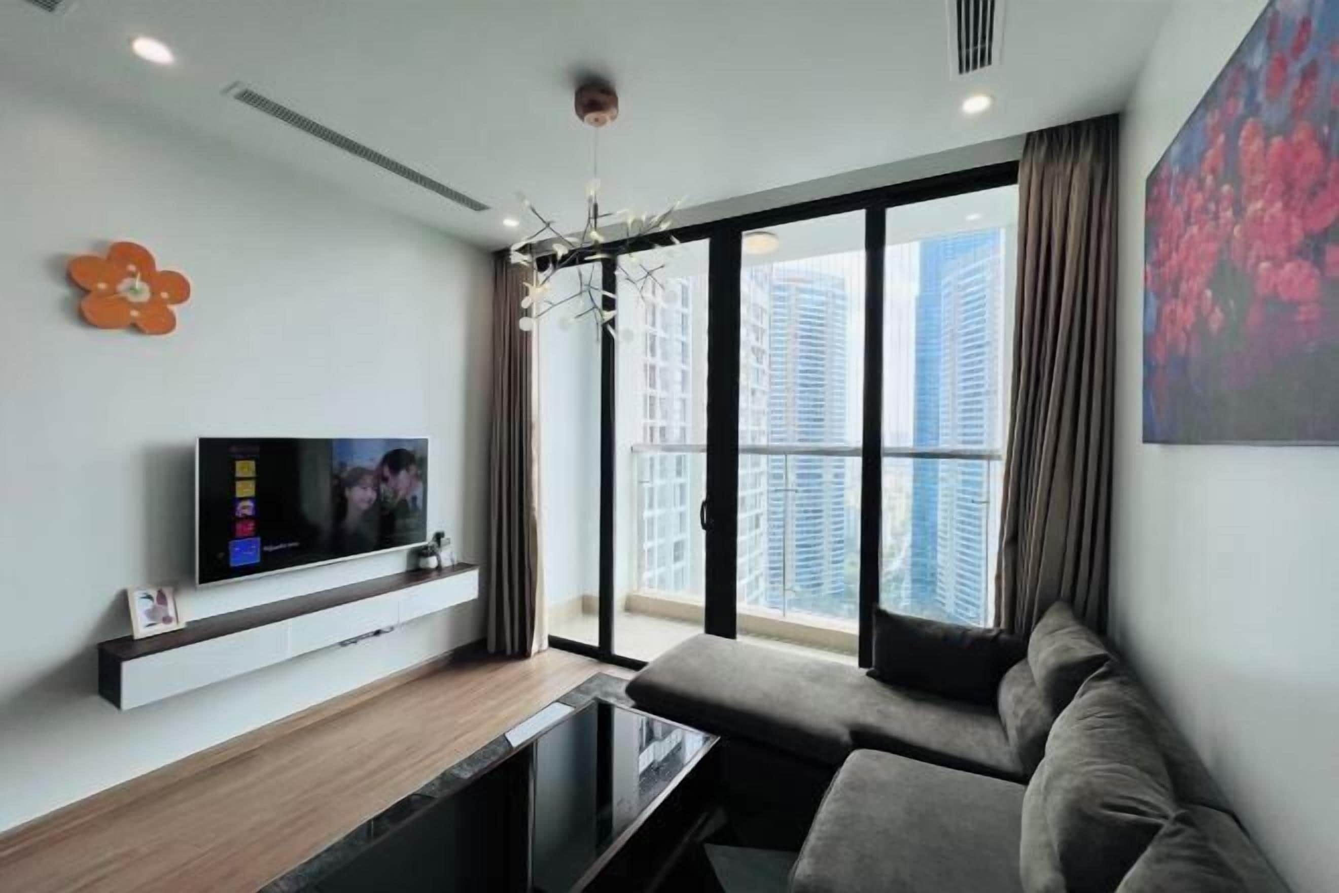 Ein modernes Wohnzimmer mit einem großen Fenster, einem Flachbildfernseher und einem Sofa.