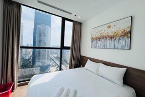 A hotel room with a large bed, a city view, and a painting on the wall. - Alex'housing Vinhome D'capitale luxury apartment (Hanoi)