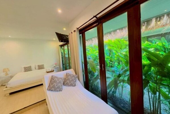 Quarto moderno com uma janela grande, uma cama e uma mesa de cabeceira.
