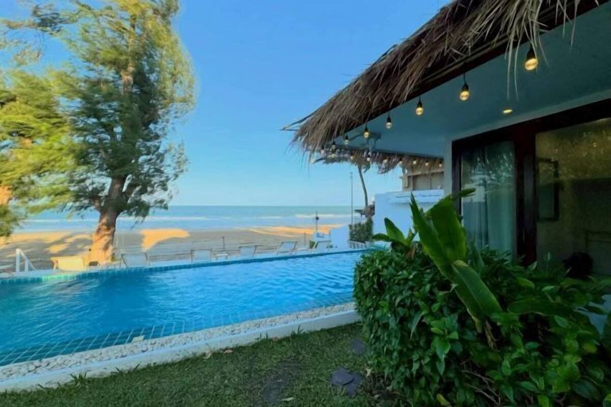 A poolside view with a clear view of the beach and ocean.
