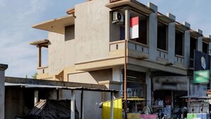 A multi-story building with a flat roof, large windows, and a visible flag. - Soka Asri Guest House near Bali Zoo RedPartner (Bali)