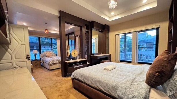 Een slaapkamer met een groot bed, een bureau, een stoel en een raam met uitzicht.