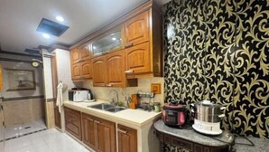 Een keuken met houten kastjes, een spoelbak, een aanrecht en een decoratieve achterwand.