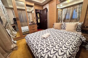 Une chambre à coucher avec un grand lit, une armoire et un miroir.