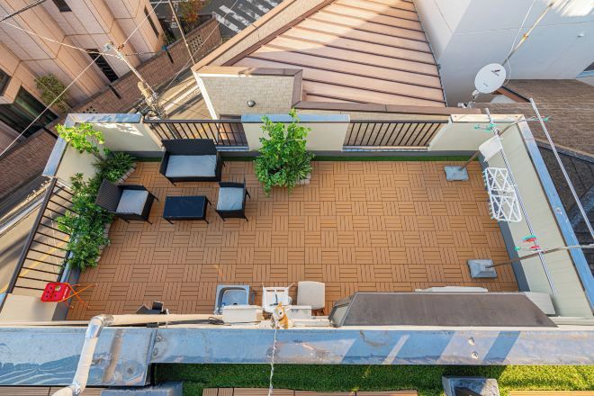 A rooftop terrace with outdoor seating, a barbecue area, and potted plants.