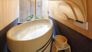 A modern bathroom with a large wooden bathtub, a small wooden stool, and a wall-mounted wooden panel. - Kyo No Ondokoro Kamanza Nijo #2 (Kyoto)