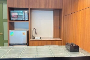 A compact kitchenette with a microwave, refrigerator, sink, and a small countertop. - Nueng Rana 113 Unique House in China Town/3BR 2BA (Bangkok)