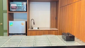 Une cuisine compacte équipée d’un four à micro-ondes, d’un réfrigérateur, d’un évier et d’une cuisinière à gaz.