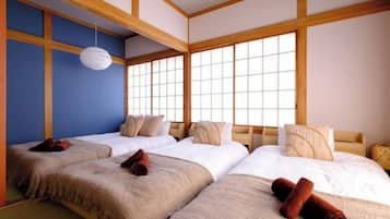 A traditional Japanese-style room with tatami flooring, a shoji screen, and a wooden ceiling.