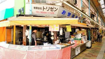 A food stall with a checkered tablecloth, a signboard, and a person behind the counter.