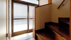 A wooden staircase leading to a room with a sliding glass door. - Board Game House Tokyo (Tokyo)