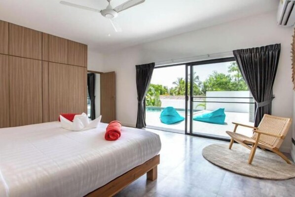 Une chambre à coucher avec un lit, une chaise et une vue sur l’extérieur.