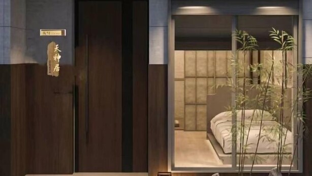 Una habitación de hotel con un ventanal grande, una cama y una planta.