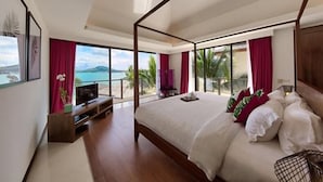 A modern bedroom with a large bed, a TV, and a balcony with a view of the sea. - Baan Benjamart (Koh Samui)