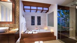 A modern bathroom with a freestanding bathtub, a large mirror, and a glass shower enclosure. - Baan Benjamart (Koh Samui)