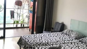 Un dormitorio moderno con una cama, una silla y un ventanal grande.