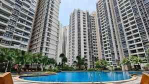 Un conjunto de edificios residenciales altos con piscina y palmeras.