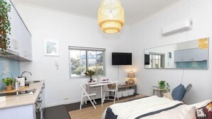 Une chambre à coucher moderne, avec un lit, une table de chevet et un bureau avec une chaise.