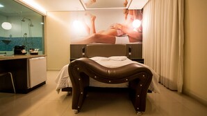 A hotel room with a bed, a desk, a mirror, and a shower area. - Motel Vitara (Taboão da Serra)