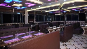 Un restaurant doté d’un éclairage moderne, de banquettes et de tables.