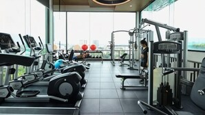 A gym with cardio machines, weightlifting equipment, and a view of the city. - Specious Luxury 2 bedrooms Apt. (Chiang Mai)