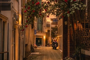 A narrow alleyway with a motorcycle parked at the end, flanked by buildings with visible balconies and a gate on the right. - Turtle Stay Seoul-- the Center of Seoul #Cozy Apartment (Seoul)
