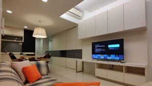 Un salon moderne doté d’un téléviseur à écran plat, d’un canapé et d’un coin repas.