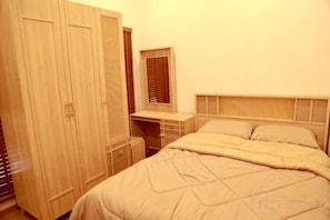 A bedroom with a bed, a wardrobe, a desk, and a mirror. - Taka Onzen (Kaeng Khoi)