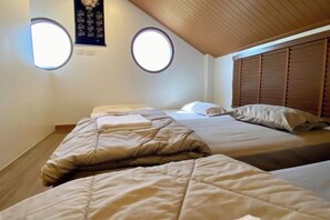 A room with two beds, a wooden ceiling, and two round windows. - Taka Onzen (Kaeng Khoi)