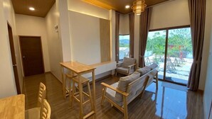 Una sala de estar moderna con piso de madera, un sofá, una mesa y una silla.