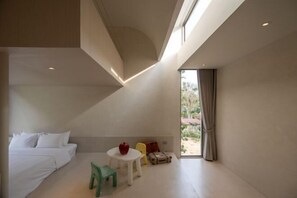 A modern hotel room with a bed, a small table with a red object, a green chair, and a suitcase. - Number Three Pool Villa Khaoyai (Pak Chong)