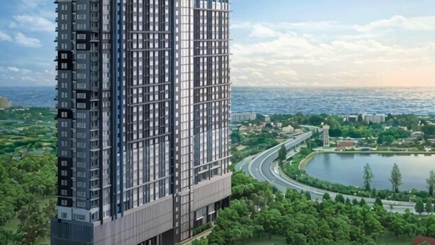 A high-rise building with a modern architectural design, surrounded by greenery and a body of water.