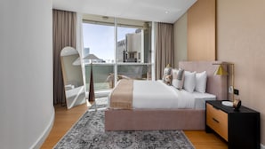 A modern hotel room with a large bed, a nightstand, a mirror, and a view of the city. - Dazzling Downtown Retreat w Panoramic City Views (Dubai)