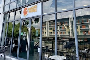 A restaurant with a glass facade, outdoor seating, and a sign indicating it is a KFC. - Urban Retreat @ K Avenue • Pool • Paid Parking (Donggongon)