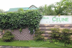 A sign for Villa Celine Resort with a stone wall and greenery. - Villa Celine Bay Laguna (Laguna)
