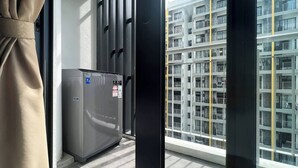 Een modern appartement met een groot raam, een ingebouwde airconditioning en uitzicht op een hoog gebouw.