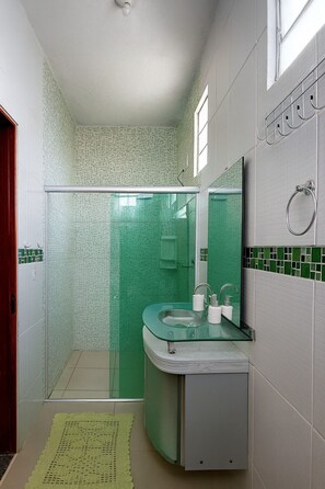 A bathroom with a glass shower enclosure, a sink with a mirror, and a towel rack. - Amazon House with Pool, Pool Table, BBQ, 5 min from the Beach (Macapá)