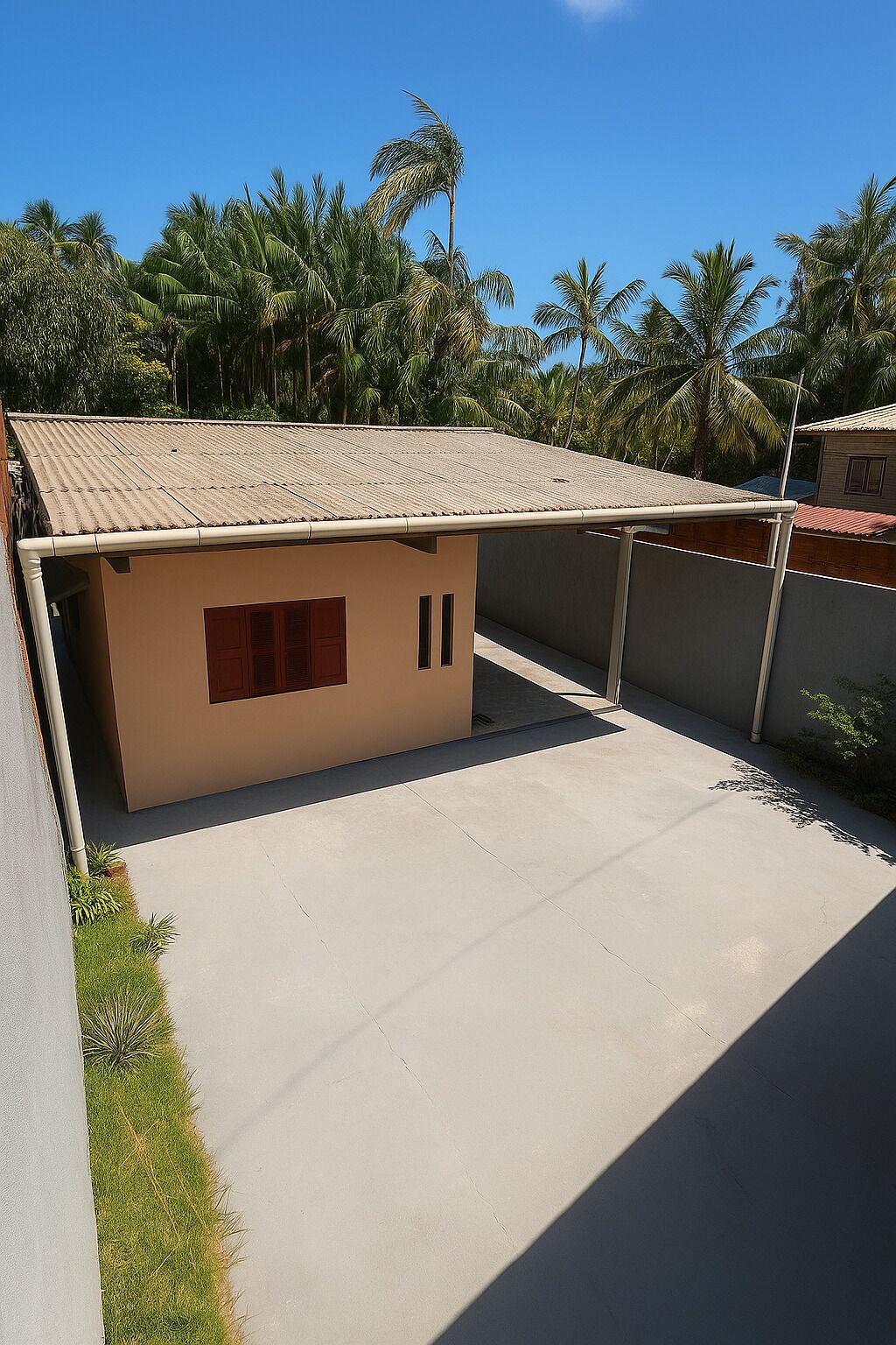 A single-story building with a flat roof, a small attached structure with a red door, and a concrete patio area.