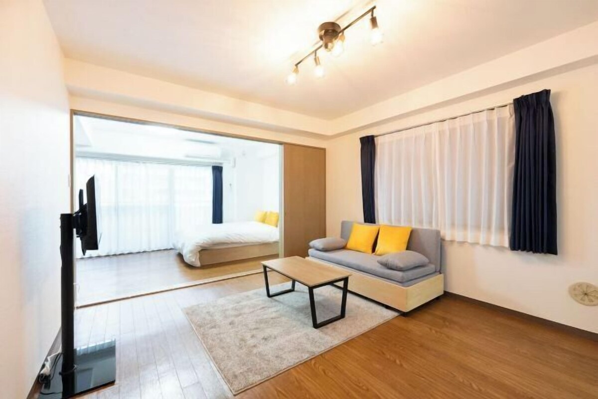 A modern living room with a sofa, a coffee table, and a TV stand.