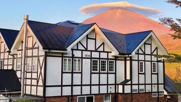 A traditional half-timbered house with a steeply pitched roof and a chimney.