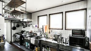 Een moderne keuken met roestvrijstalen apparatuur, een grote spoelbak en veel opbergruimte.