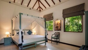 A four-poster bed with a canopy, a nightstand with a lamp, a chair, and a bench. - Ranna Beach House - Your own haven by the beach (Hambantota)
