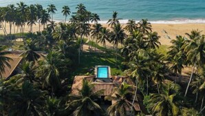 A tropical beach resort with a pool, palm trees, and ocean views. - Ranna Beach House - Your own haven by the beach (Hambantota)