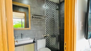 Ein modernes Badezimmer mit Toilette, Waschbecken und Dusche.