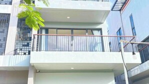 Ein modernes Gebäude mit Balkon, großen Fenstern und einer Überwachungskamera.