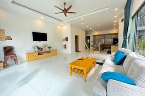 A modern living room with a sofa, coffee table, and TV. - Dream Villa Phu Quoc (Phu Quoc Island)