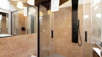 A modern bathroom with a glass shower enclosure, a sink, and a mirror.