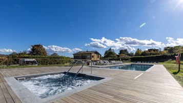 Un área de piscina con dos jacuzzis y una terraza de madera.